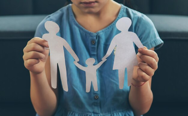 Child holding a paper cut-out of a family
