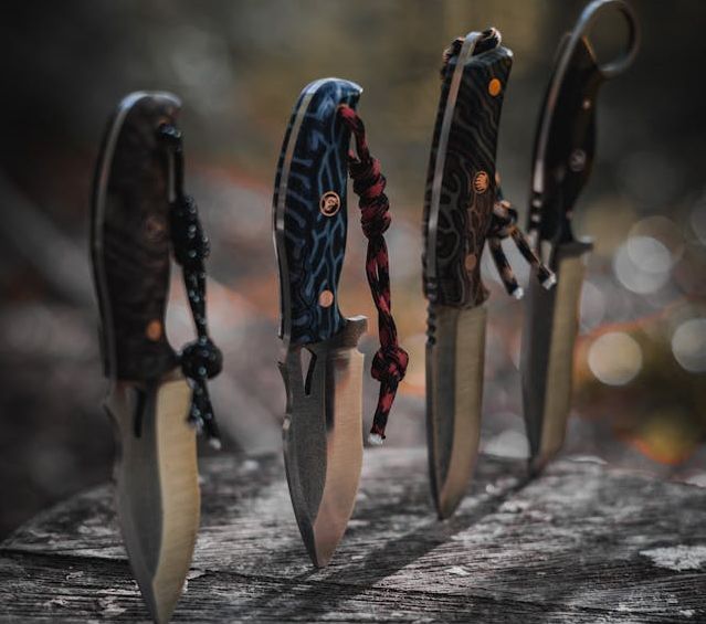  A variety of knives including chef's knife, paring knife, and serrated knife on a wooden cutting board.